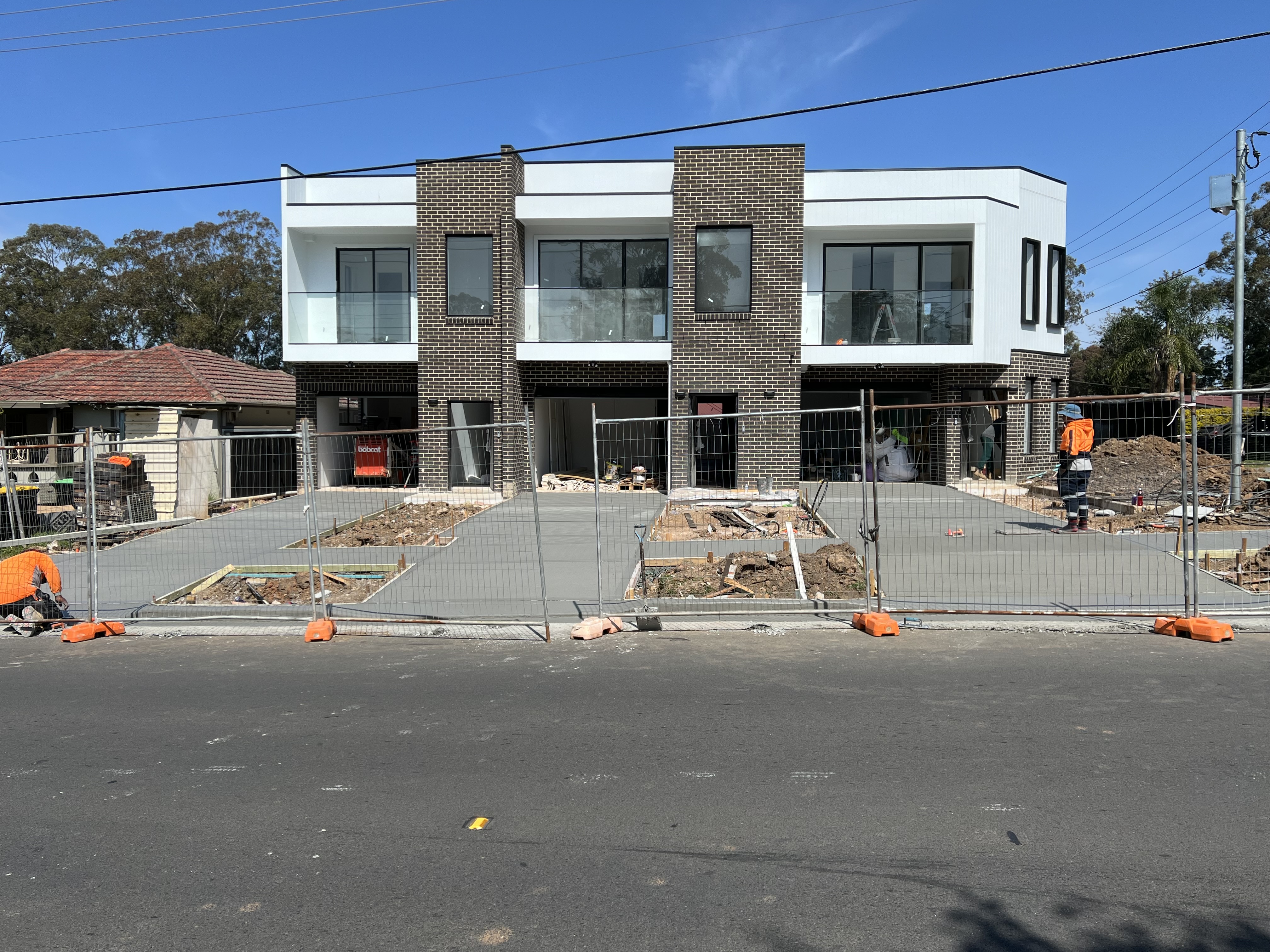 Duplex frontage with freshly poured concrete driveways and footpath
