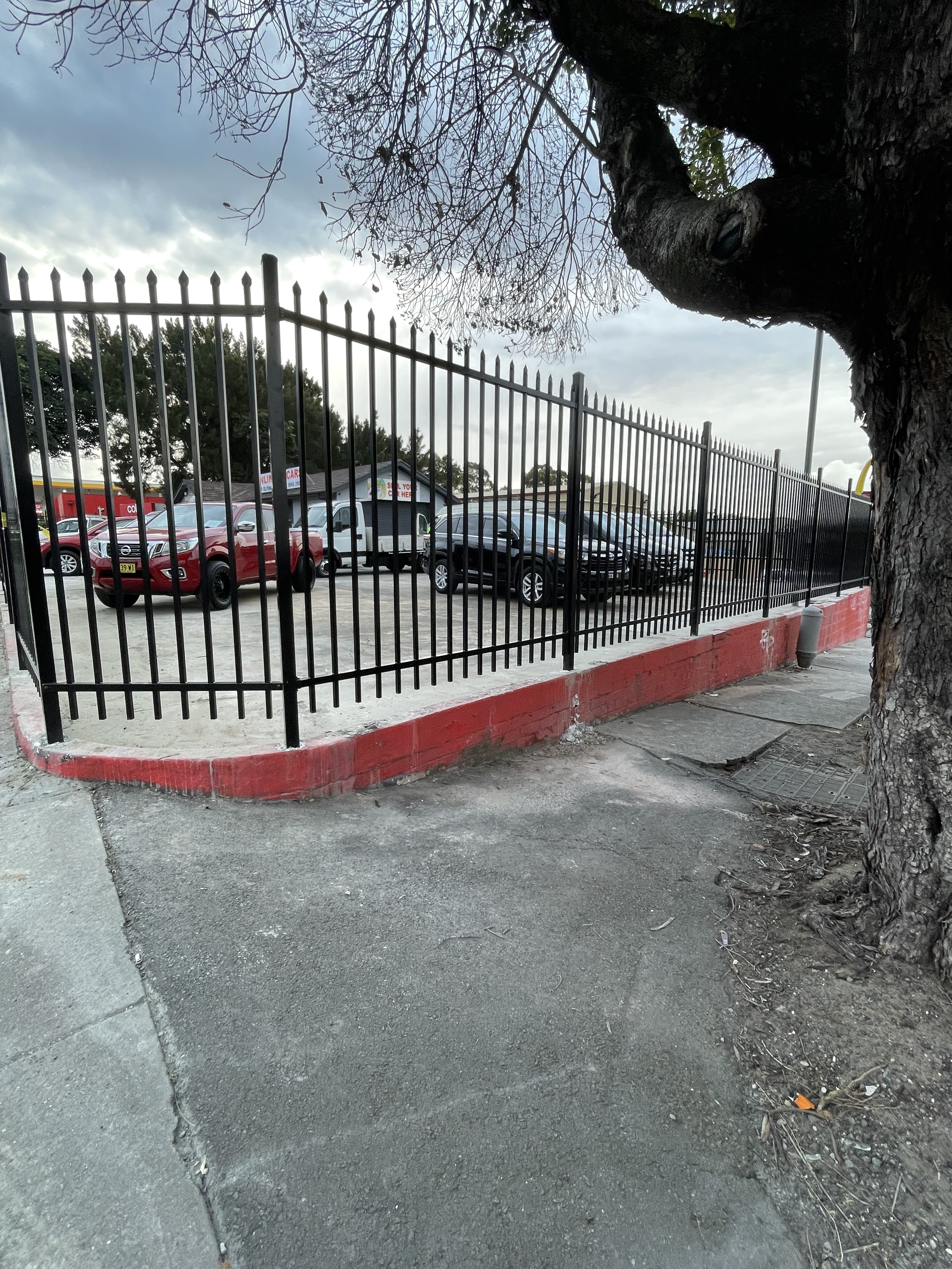 Steel security fencing corner detail with painted kerb