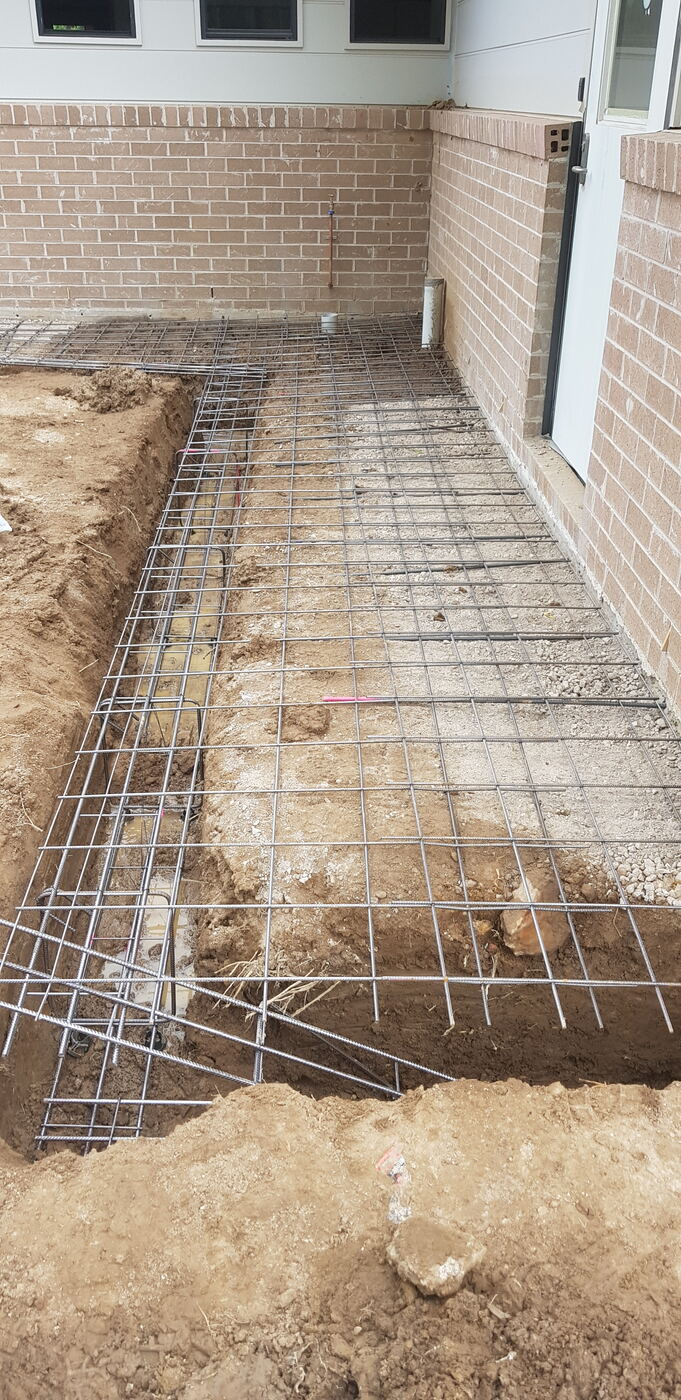 Reinforcement mesh laid along foundation wall footing
